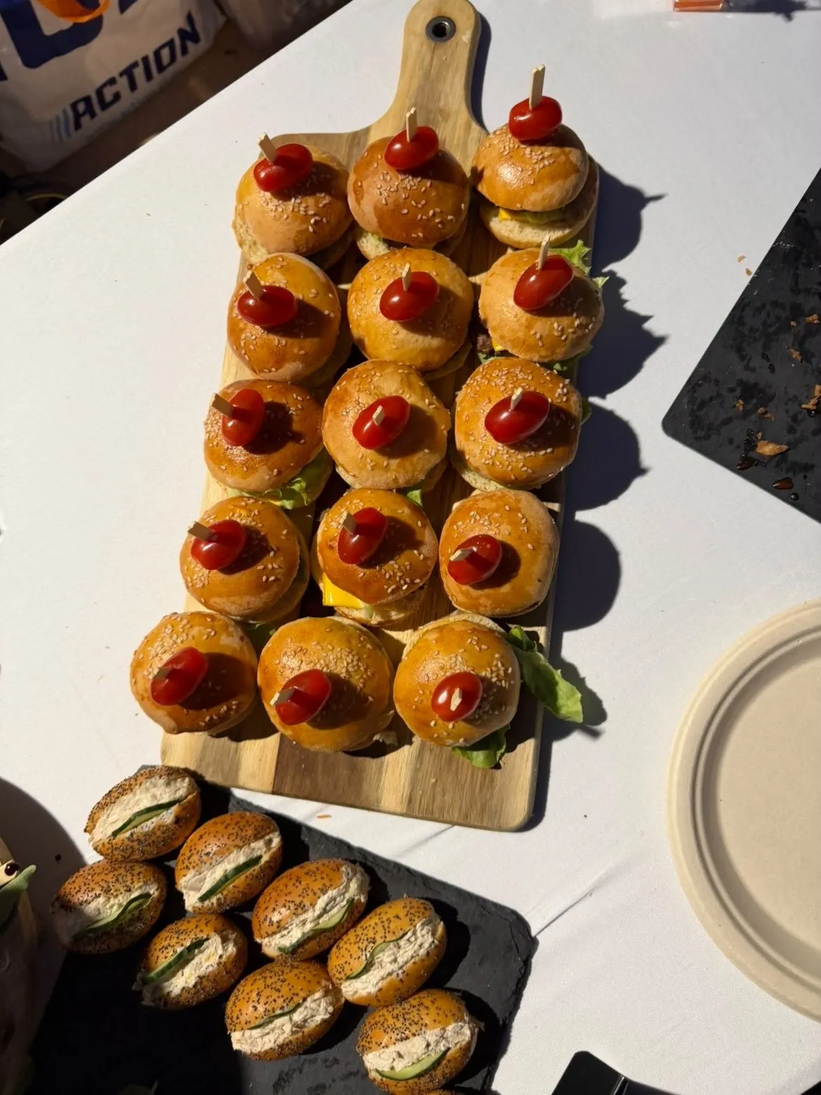 Planche de mini-burgers surmontés d'une tomate cerise