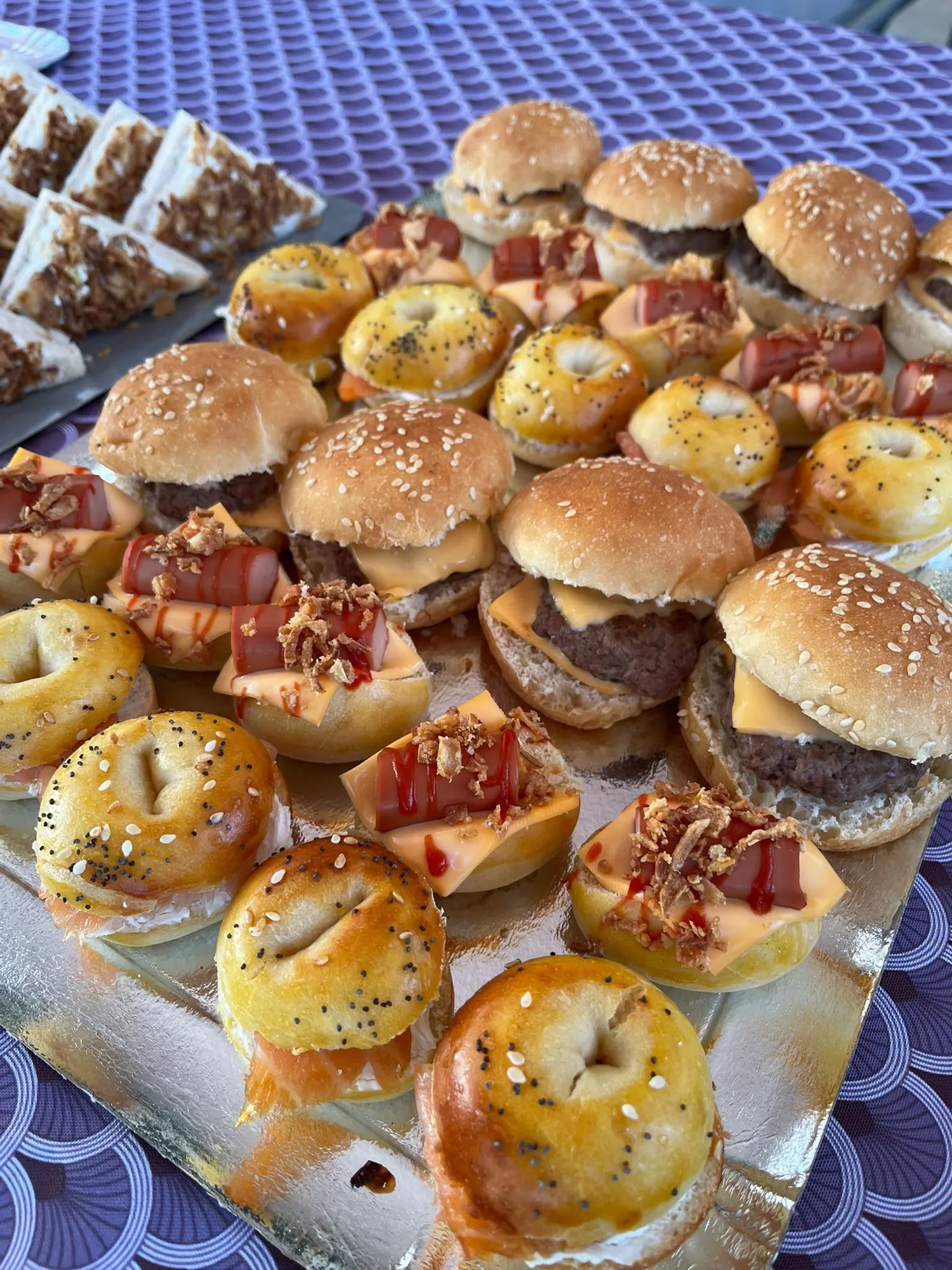 Assortiment de mini-burgers, mini-bagels au saumon et mini hot-dogs