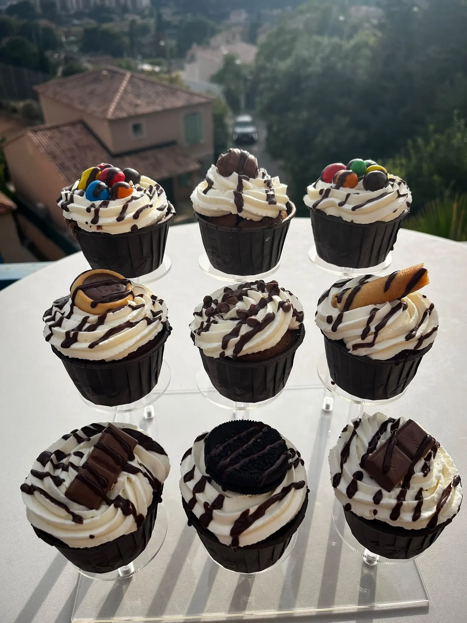 Neuf cupcakes chocolat et chantilly aux décors variés