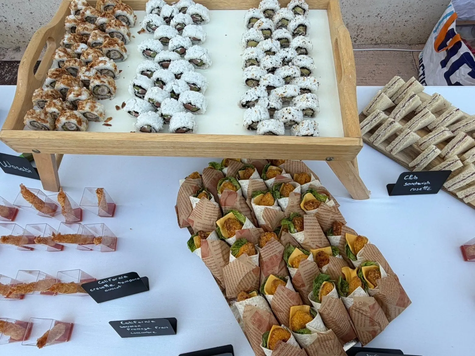 Plateau de california rolls et wraps au poulet croustillant présentés sur un buffet